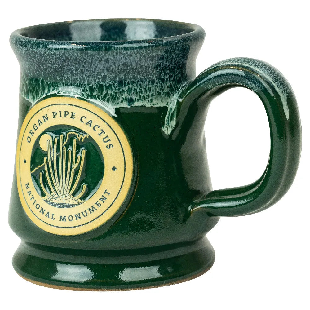 Green ceramic mug with a circular design featuring text and graphics on a white background