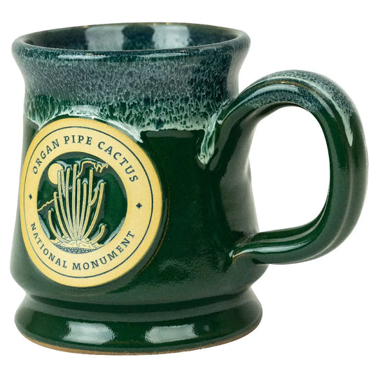 Green ceramic mug with a circular design featuring text and graphics on a white background