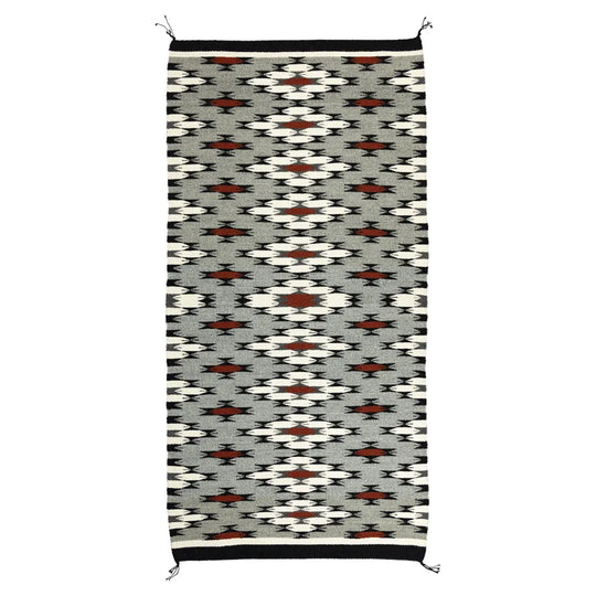 Navajo woven rug with geometric pattern on a white background