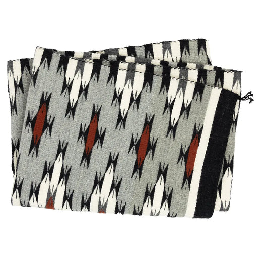 Folded Navajo weaving with a geometric pattern on a white background