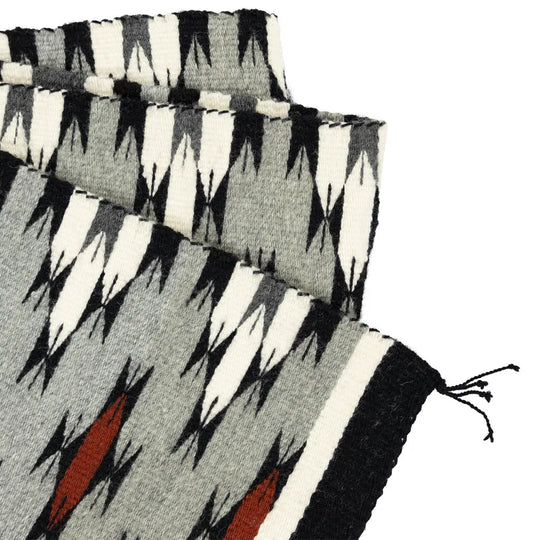 Navajo textile with geometric pattern on a white background