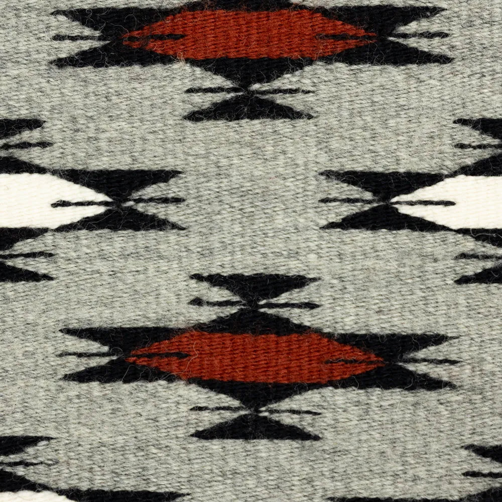 Close-up of Navajo textile with red, black, and gray colors.