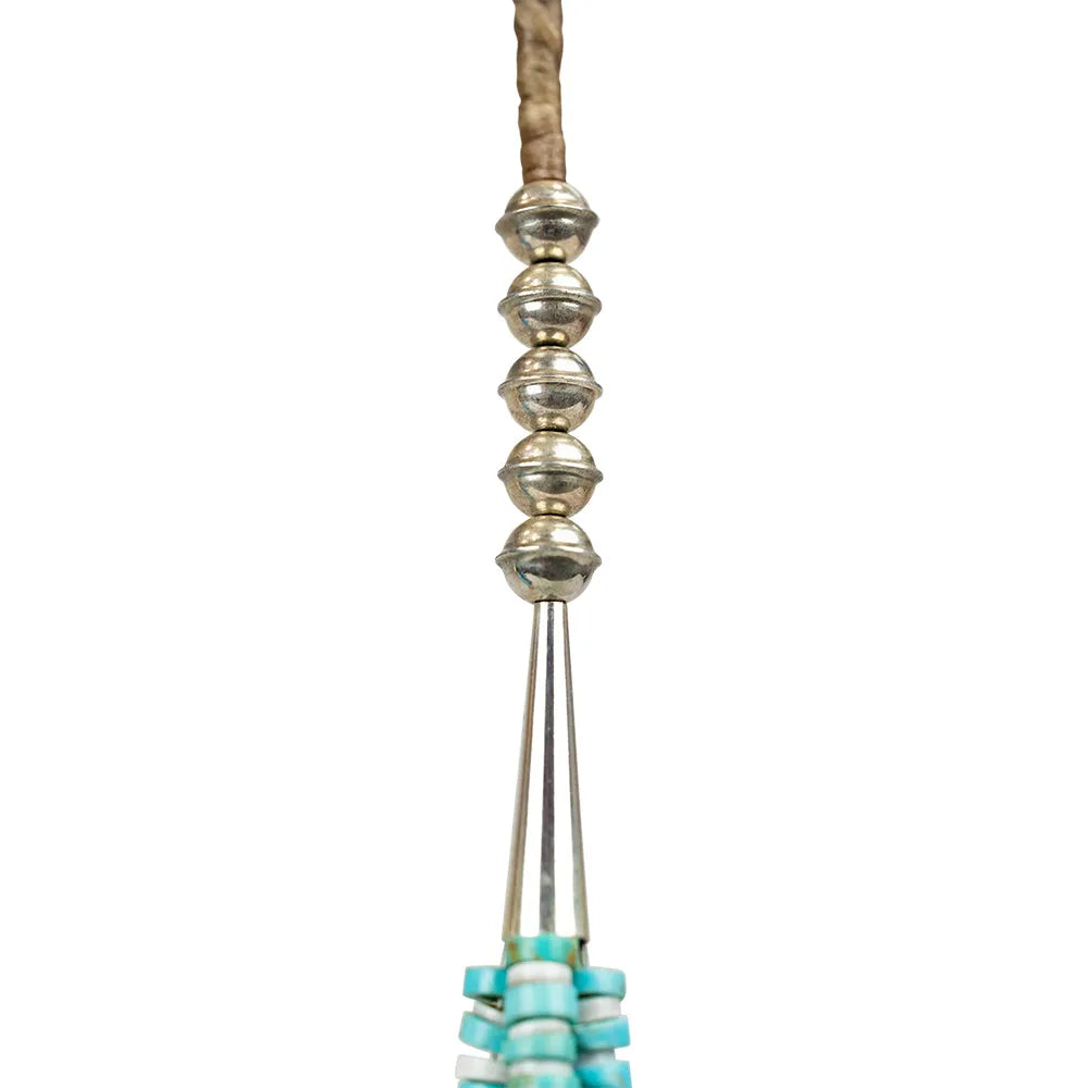 Navajo necklace detail with silver and turquoise beads on a white background