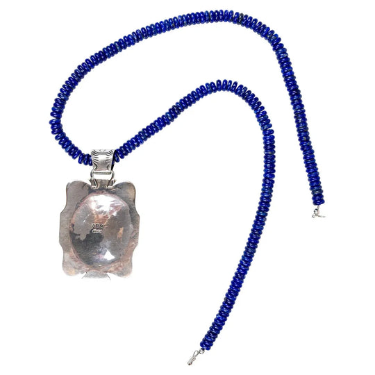 Necklace with blue beads and a silver pendant on a white background