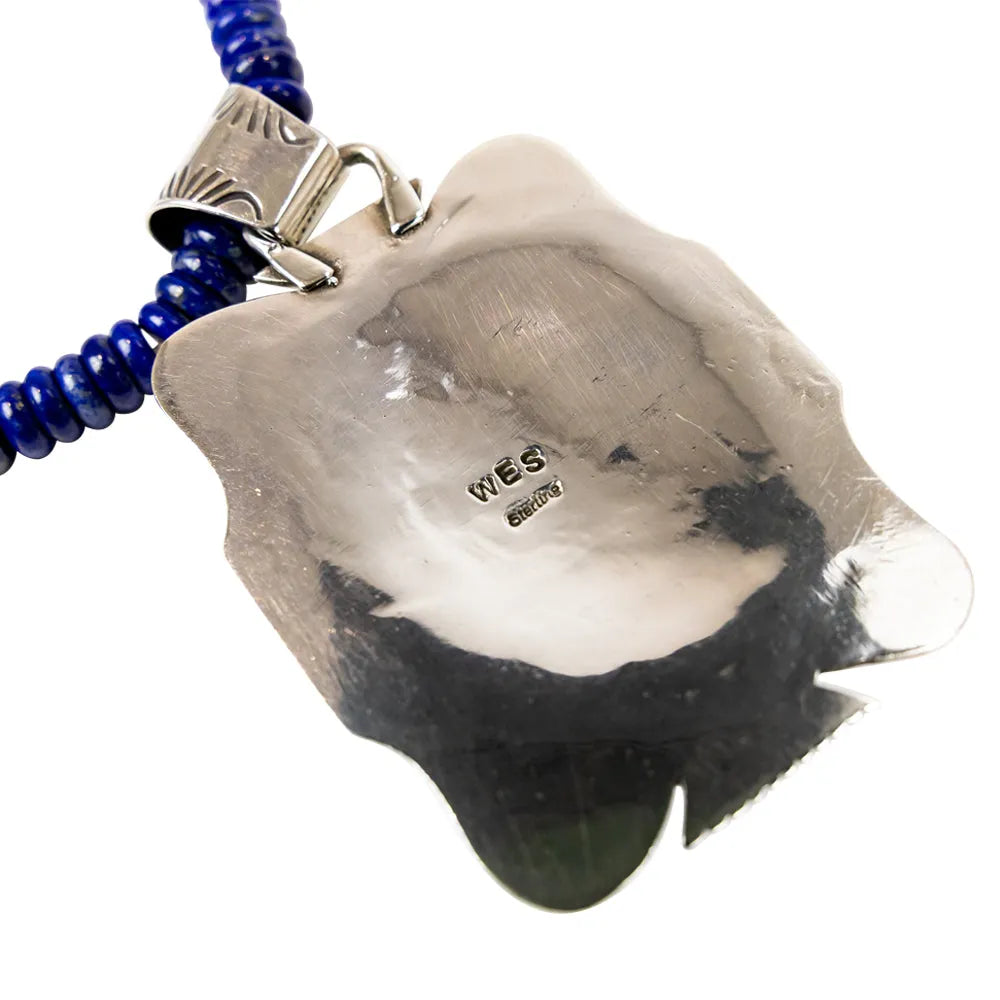 Necklace with a large, rough-textured stone pendant and blue beaded chain on a white background.