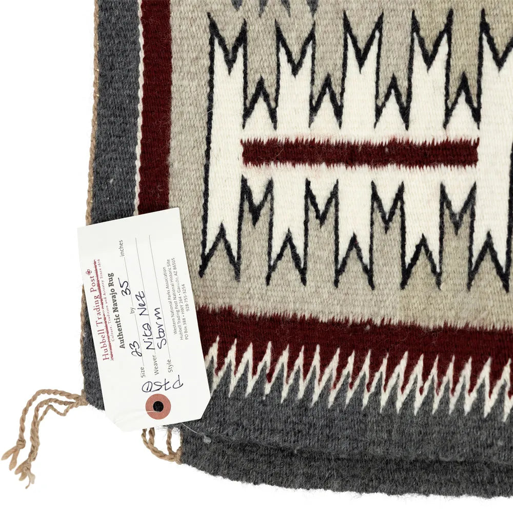 Navajo textile with geometric pattern and a certificate of authenticity on a white background