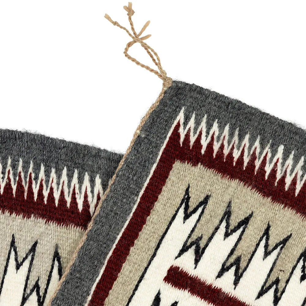 Close-up of a woven textile with geometric patterns on a white background