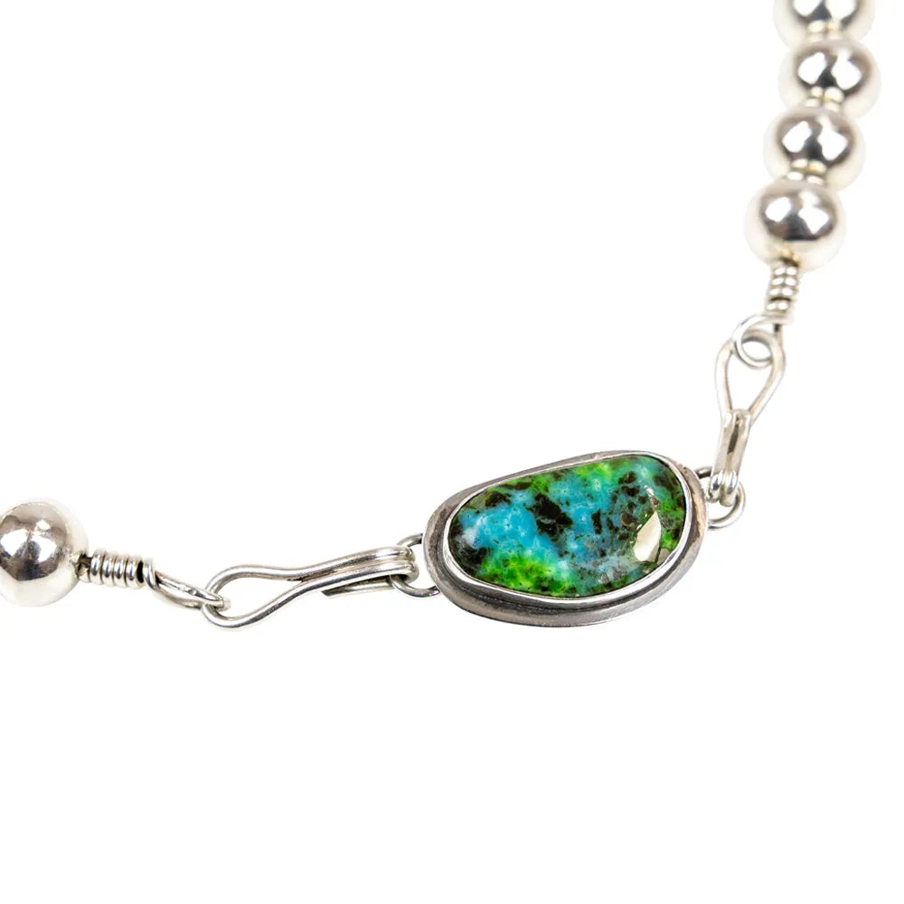 Silver beaded choker necklace with a green and blue stone clasp on a white background