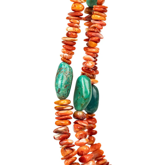 Detail of Navajo necklace with orange and turquoise beads on a white background