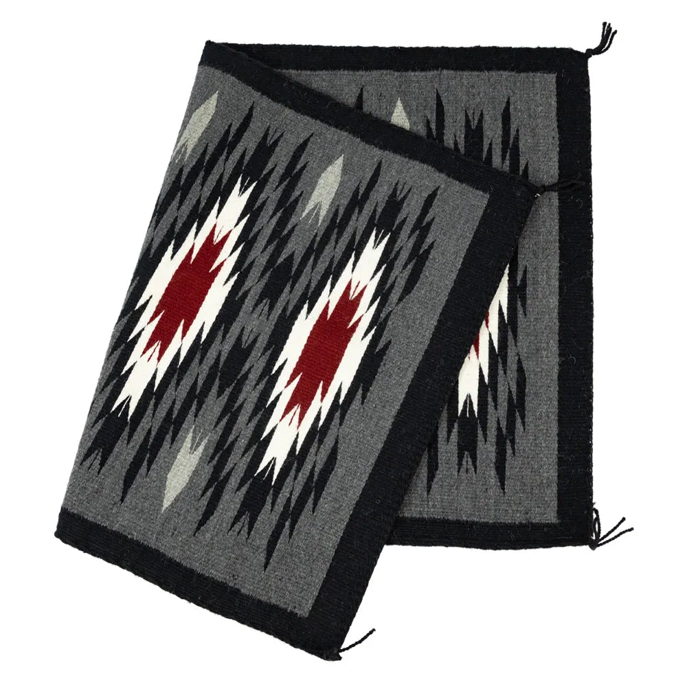 Folded view of Vallero Star Navajo Rug by Stella Paul on white background.