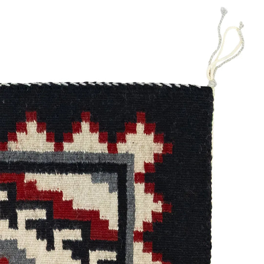 Close-up of a woven textile with geometric pattern on a white background