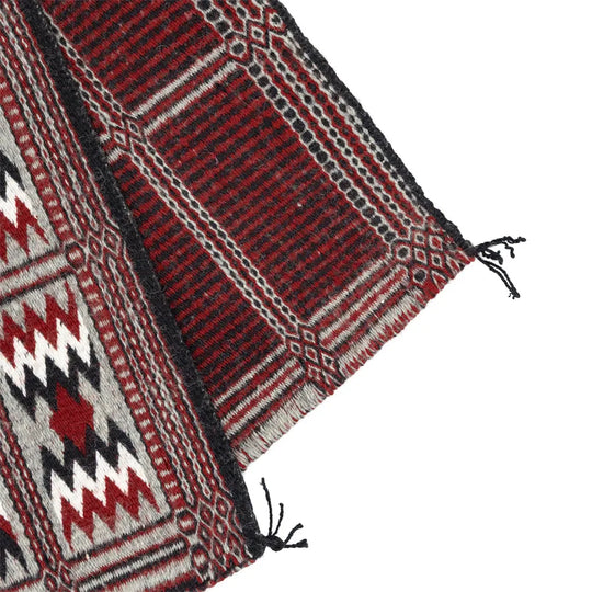 Corner detail of folded Navajo rug showing the different patterns on each side.