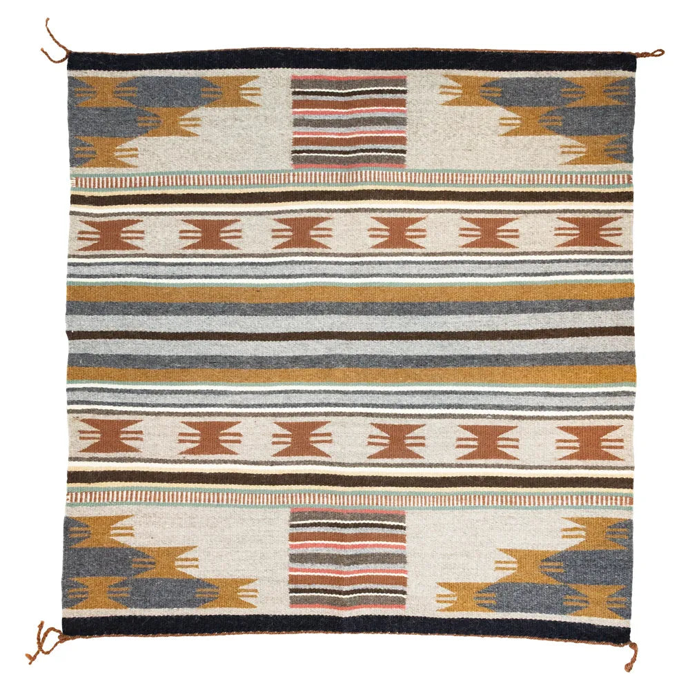 Handwoven Wide Ruins rug by Santanna Begay. Natural and plant-dyed wool bands echo the desert landscape and Navajo tradition.