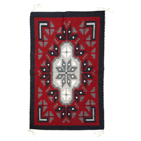 Ganado Red rug by Linda Joe. Bold red wool with central diamond motif reflects Navajo weaving traditions and history.