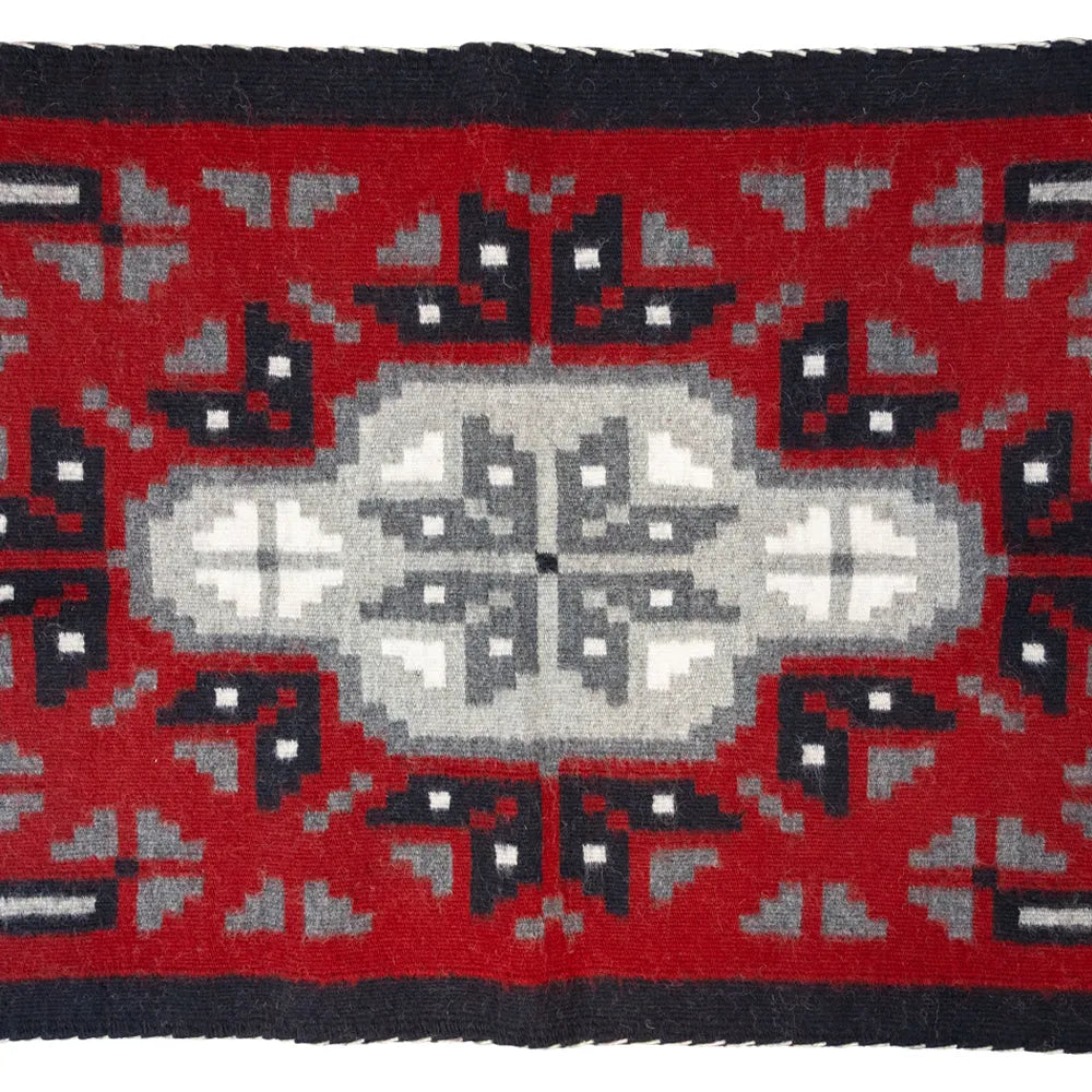 Ganado Red rug by Linda Joe. Bold red wool with central diamond motif reflects Navajo weaving traditions and history.