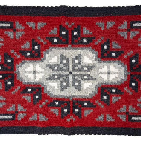 Ganado Red rug by Linda Joe. Bold red wool with central diamond motif reflects Navajo weaving traditions and history.