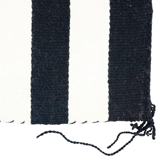 Striped Navajo blanket with black, white, and blue horizontal stripes on a white background