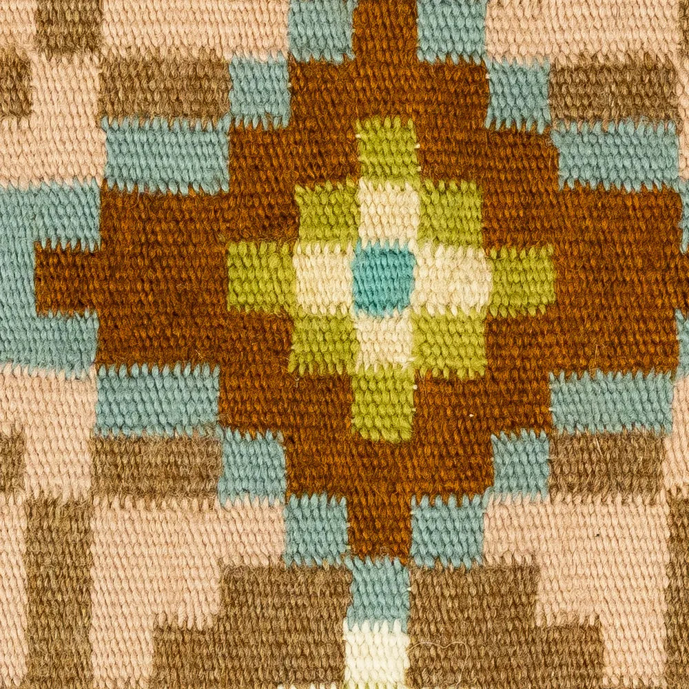Close-up of a woven fabric with a geometric pattern featuring brown, green, and blue colors.