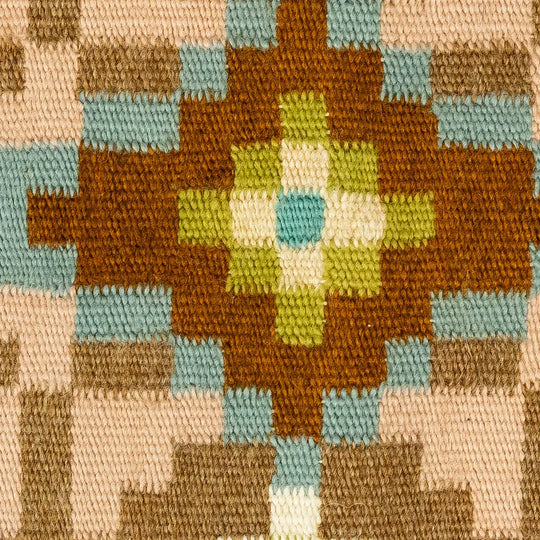 Close-up of a woven fabric with a geometric pattern featuring brown, green, and blue colors.