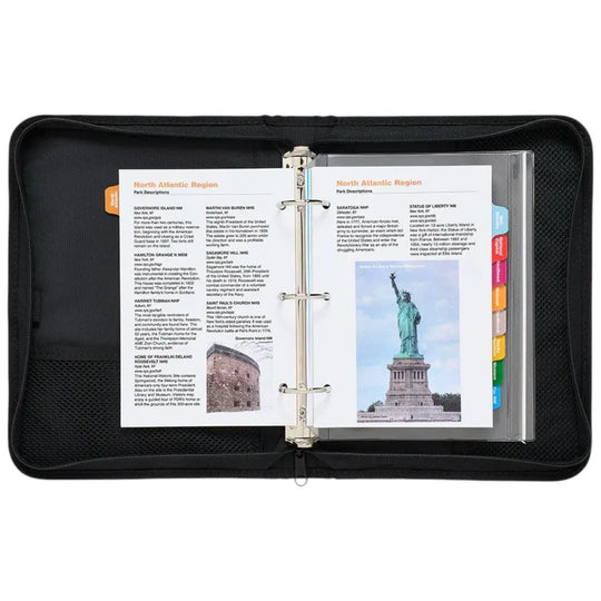 Black binder with open pages showing text and images, including a statue of liberty, on a white background.
