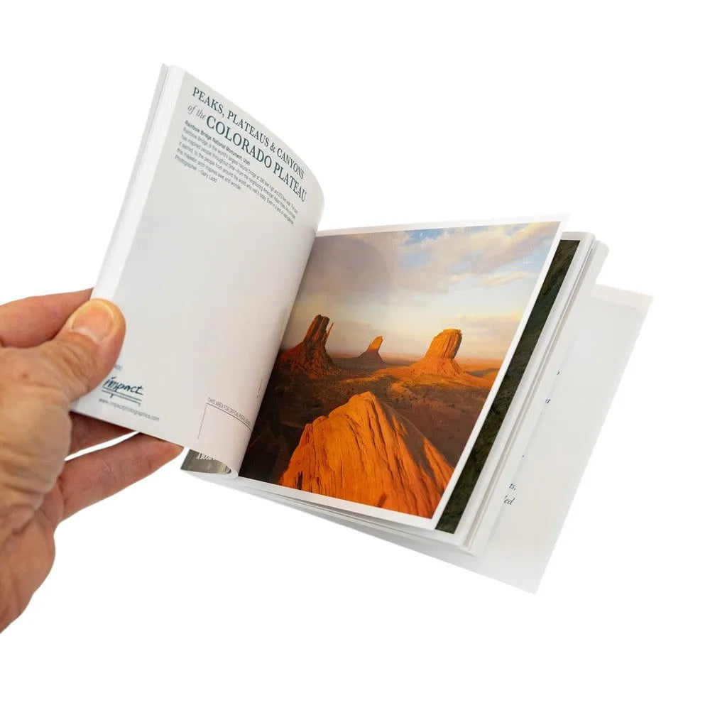 Open book showing a page with a desert landscape illustration, held by a hand.