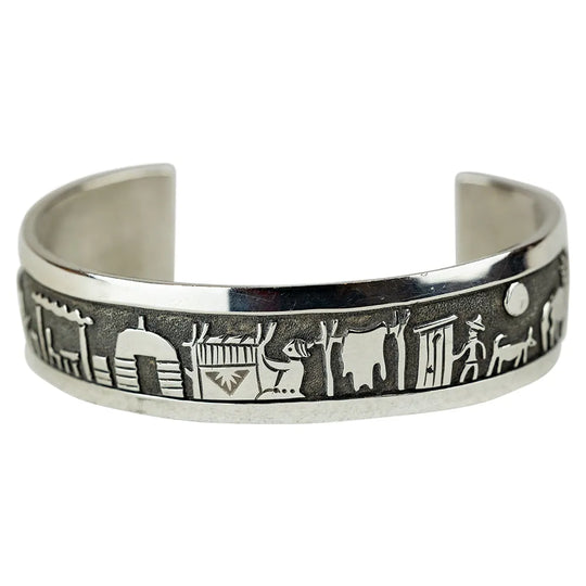 Silver bracelet with embossed designs on a white background