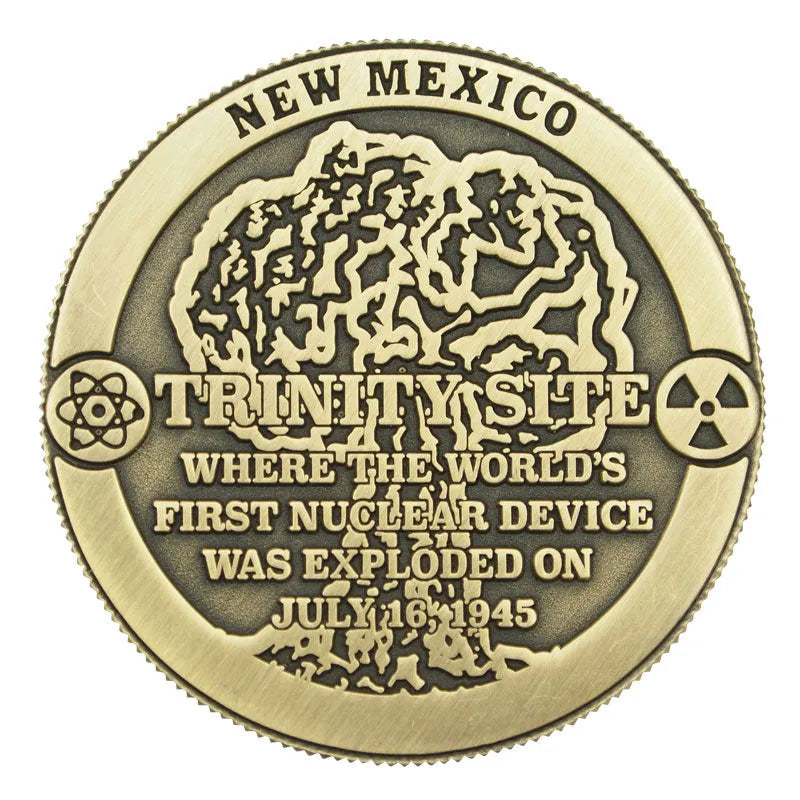 Bronze coin commemorating the Trinity Site in New Mexico with text about the world's first nuclear device explosion.