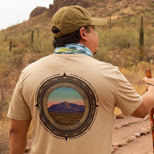 back view of man hiking on desert trail in performance t-shirt