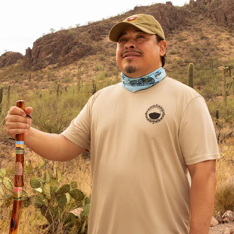 Front view of man hiking on desert trail in performance t-shirt