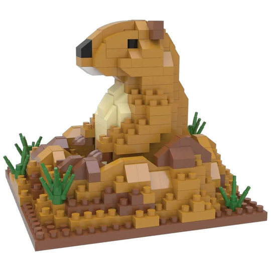 A small animal building block model of a brown and tan prairie dog, constructed from interlocking toy bricks with green grass and brown rocks on a white background.