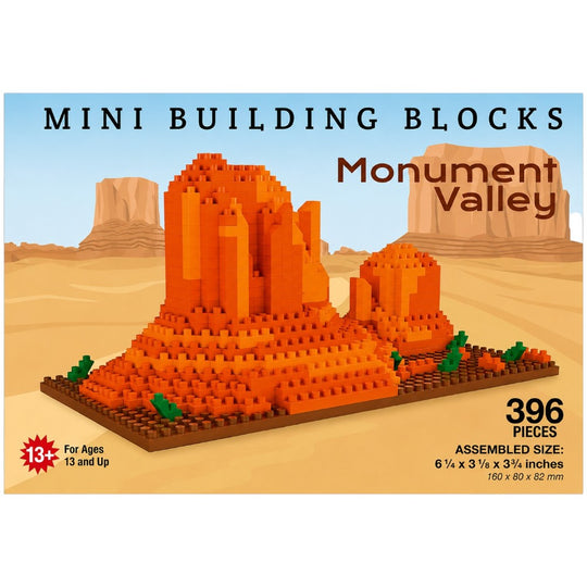 Mini Building Blocks set for Monument Valley, featuring a 3D brick-built desert landscape with orange sandstone buttes on a sandy beige base, shown on a light blue and beige illustrated background with product text overlays.