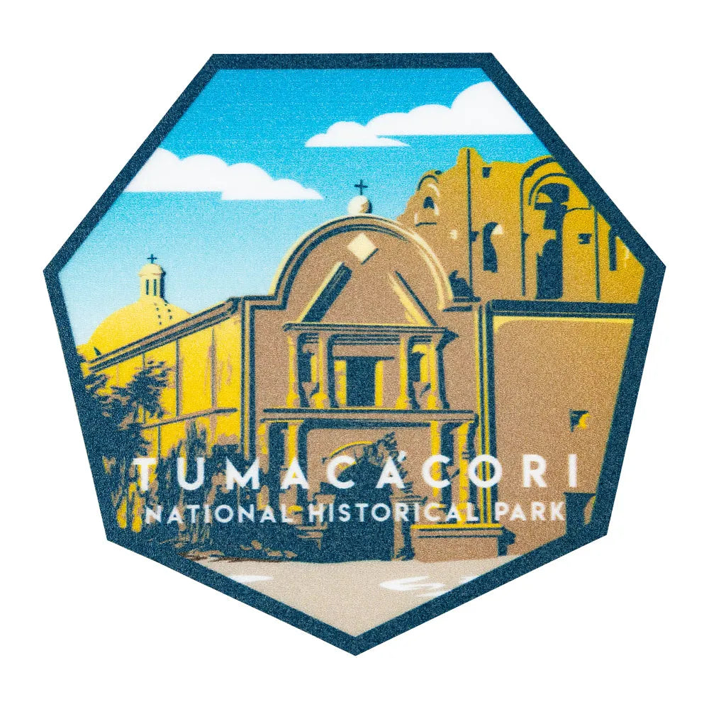 Hexagonal logo of Tumacócori National Historical Park with a building and blue sky.