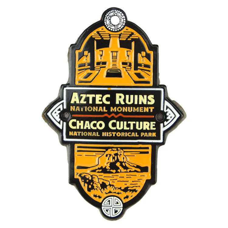 Hiking stick medallion for Aztec Ruins National Monument and Chaco Culture National Historical Park with orange and black design.
