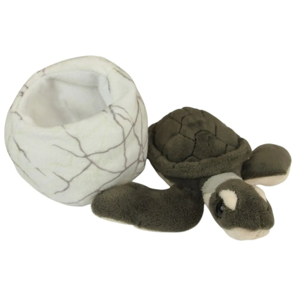 A plush turtle toy next to a matching cracked-egg-shaped nest on a plain white background.
