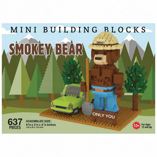 Box art for a mini building blocks set featuring a Smokey Bear character made from brown and tan blocks, wearing a straw hat and blue pants, standing beside a green car on a forest-themed illustrated background. Text includes &