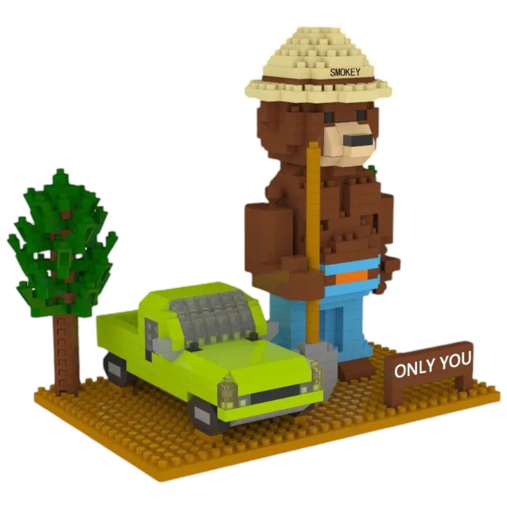 Toy figure of a bear in a hat with a green car and tree on a white background