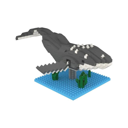 Mini building blocks of a humpback whale with a blue baseplate and green blocks representing under water plants against a white background