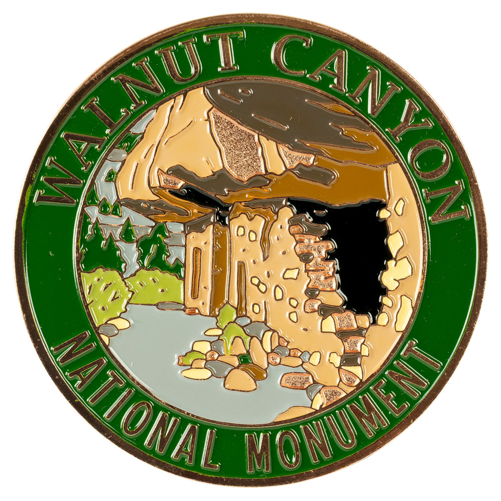 Round badge with Walnut Canyon National Monument design featuring a cliff and trees.