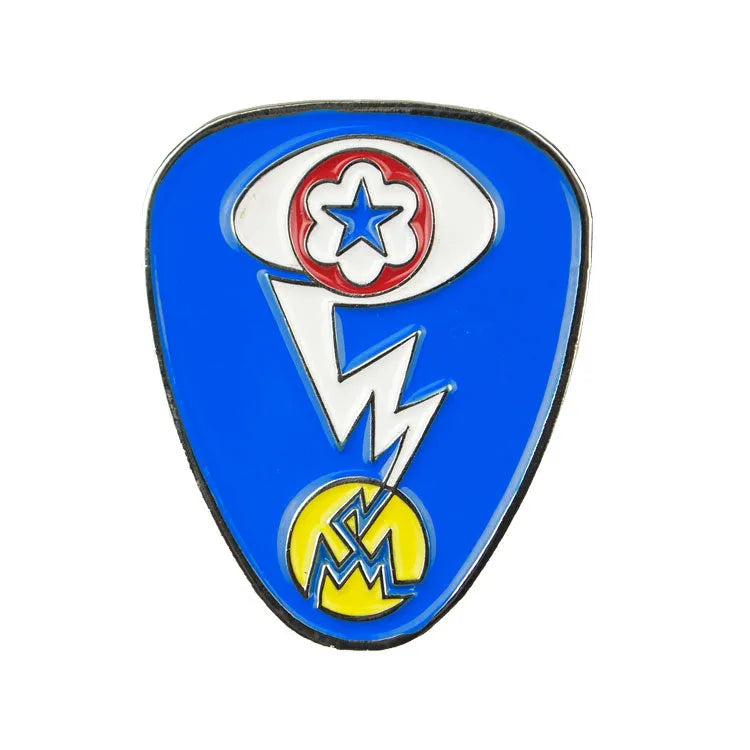 Blue badge with star, lightning bolt, and letter splitting atom design replicating the Manhattan Project on a white background