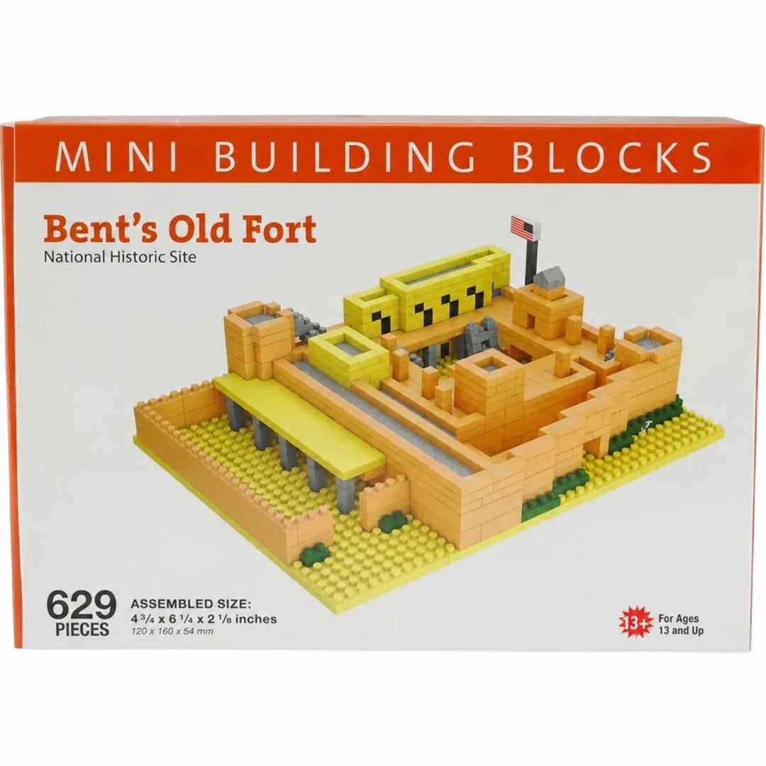 Mini Building Blocks toy box for Bent's Old Fort National Historic Site, featuring a 629-piece set of small brick buildings in yellow, orange, and gray on a white background with an orange header.