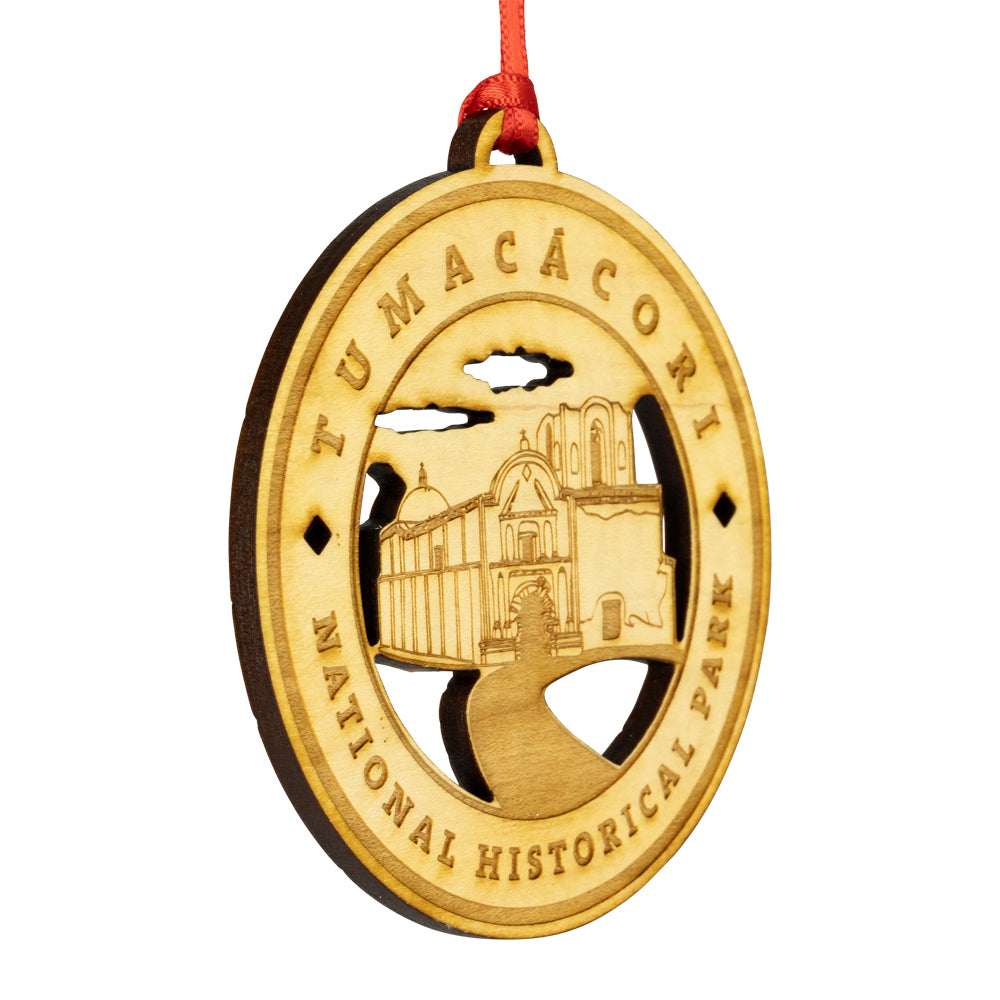 Etched wood ornament with Tumacócori National Historical Park design on a white background