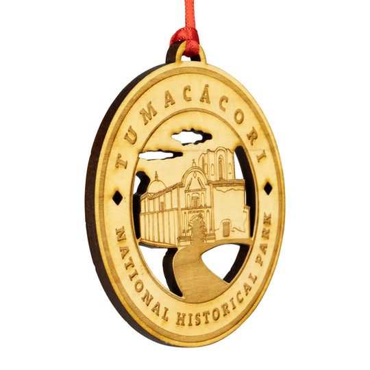 Etched wood ornament with Tumacócori National Historical Park design on a white background