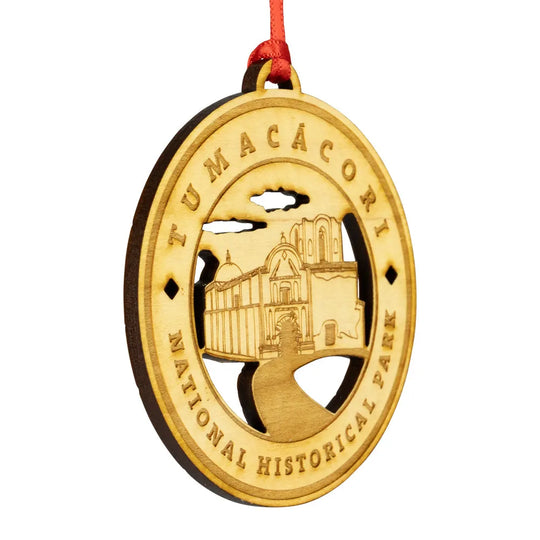 Etched wood ornament with Tumacócori National Historical Park design on a white background