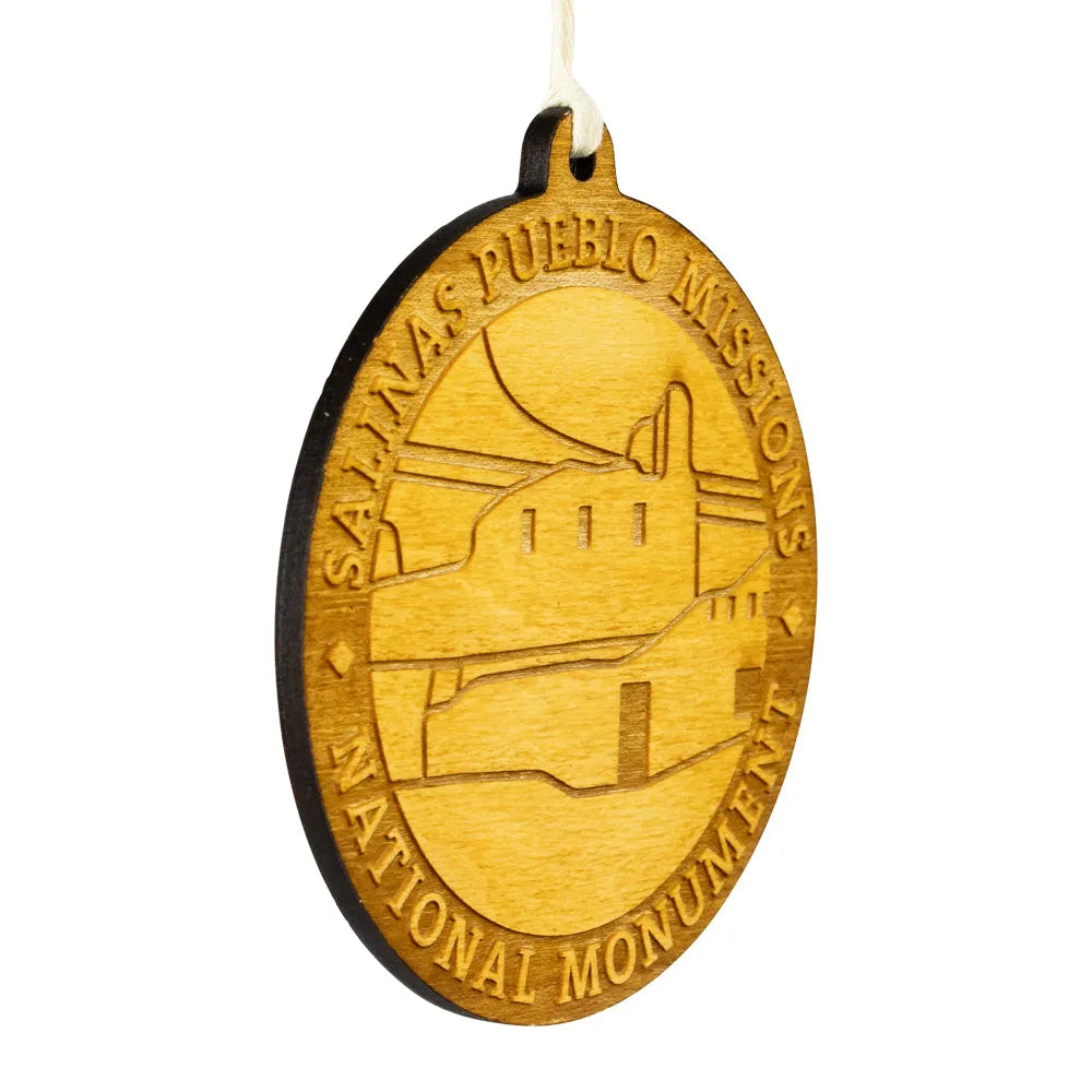 Wooden ornament with Salinas Pueblo Missions National Monument design on a white background
