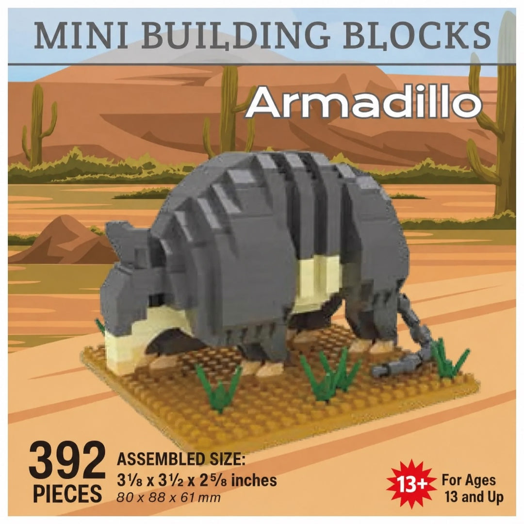 Mini Building Blocks Armadillo toy set packaging graphic showing a gray and cream block-built armadillo on a base, with desert scenery in the background and text listing 392 pieces, assembled size 3 1/2 x 3 1/2 x 2 5/8 inches, and age 13+.
