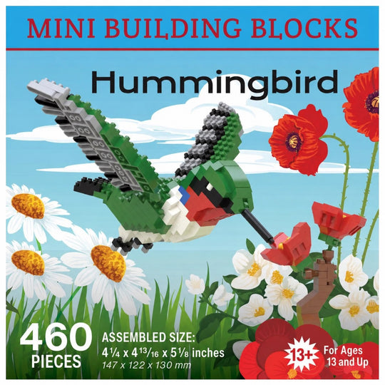 Box of mini building blocks shaped like a hummingbird with flowers on a blue sky background