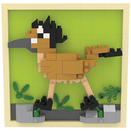 A block-built toy model of a bird, constructed from tan, black, beige, and gray plastic bricks, set against a light green background with small green and gray plant pieces.