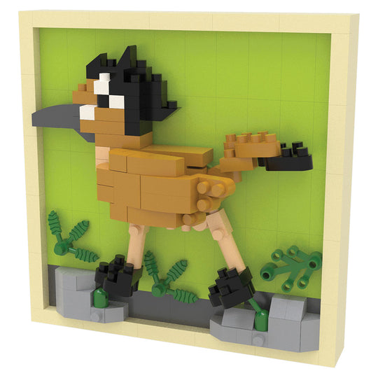 A small block-built animal figure assembled from tan, black, beige, and green toy bricks, mounted inside a light wood or beige frame against a bright green background.