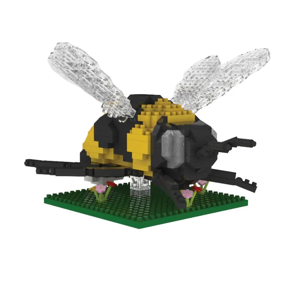 Bee mini block building set on a green plate with flowers against a white background.