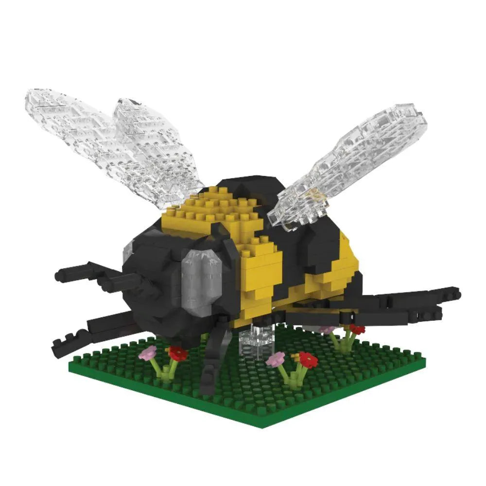 Bee mini block building set on a green plate with flowers against a white background.